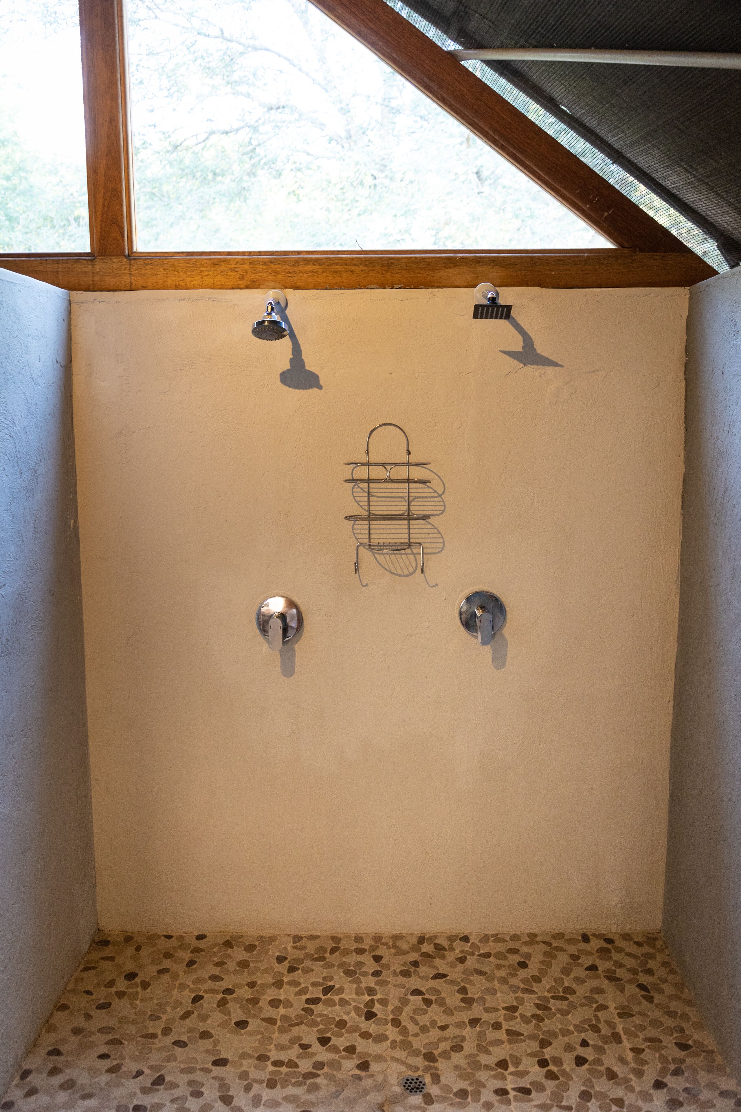 Un espacio de ducha pequeño y cerrado, con suelo de baldosas y techo de madera.