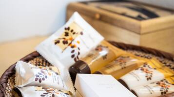 Una cesta con diversos artículos de aseo y una caja blanca con la etiqueta 'VANITY KIT' sobre una superficie de madera.