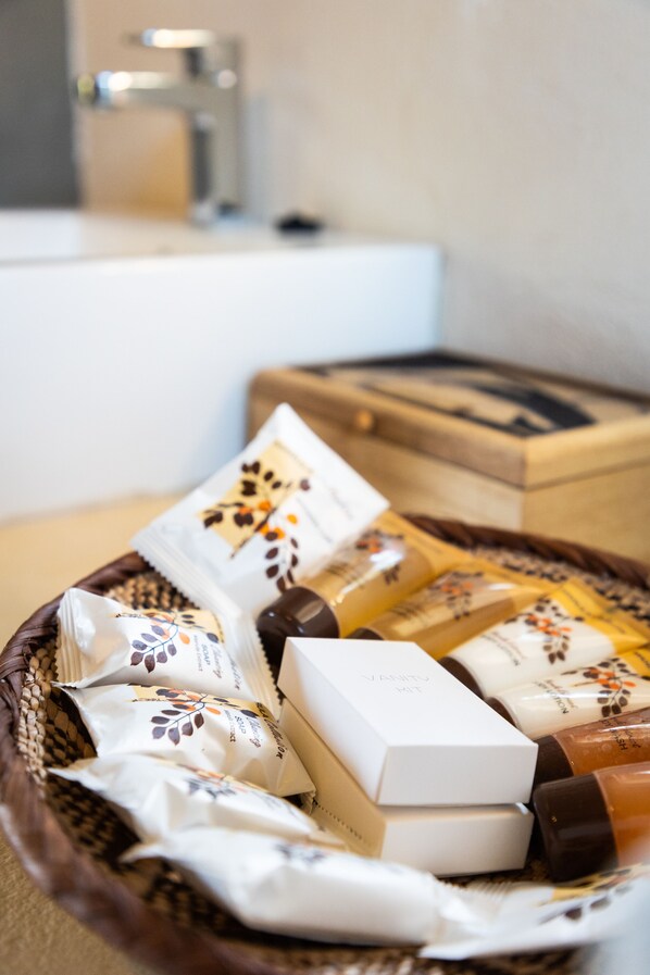 A basket containing various toiletries and a white box labeled "VANITY KIT" on a wooden surface. - MILIMA Big 5 Safari Lodge (Hoedspruit)