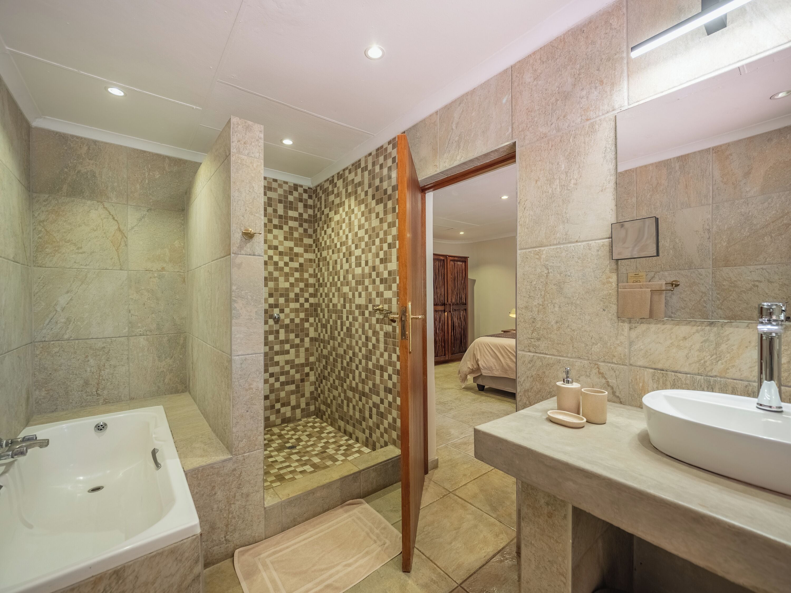 A modern bathroom with a bathtub, shower, and vanity.