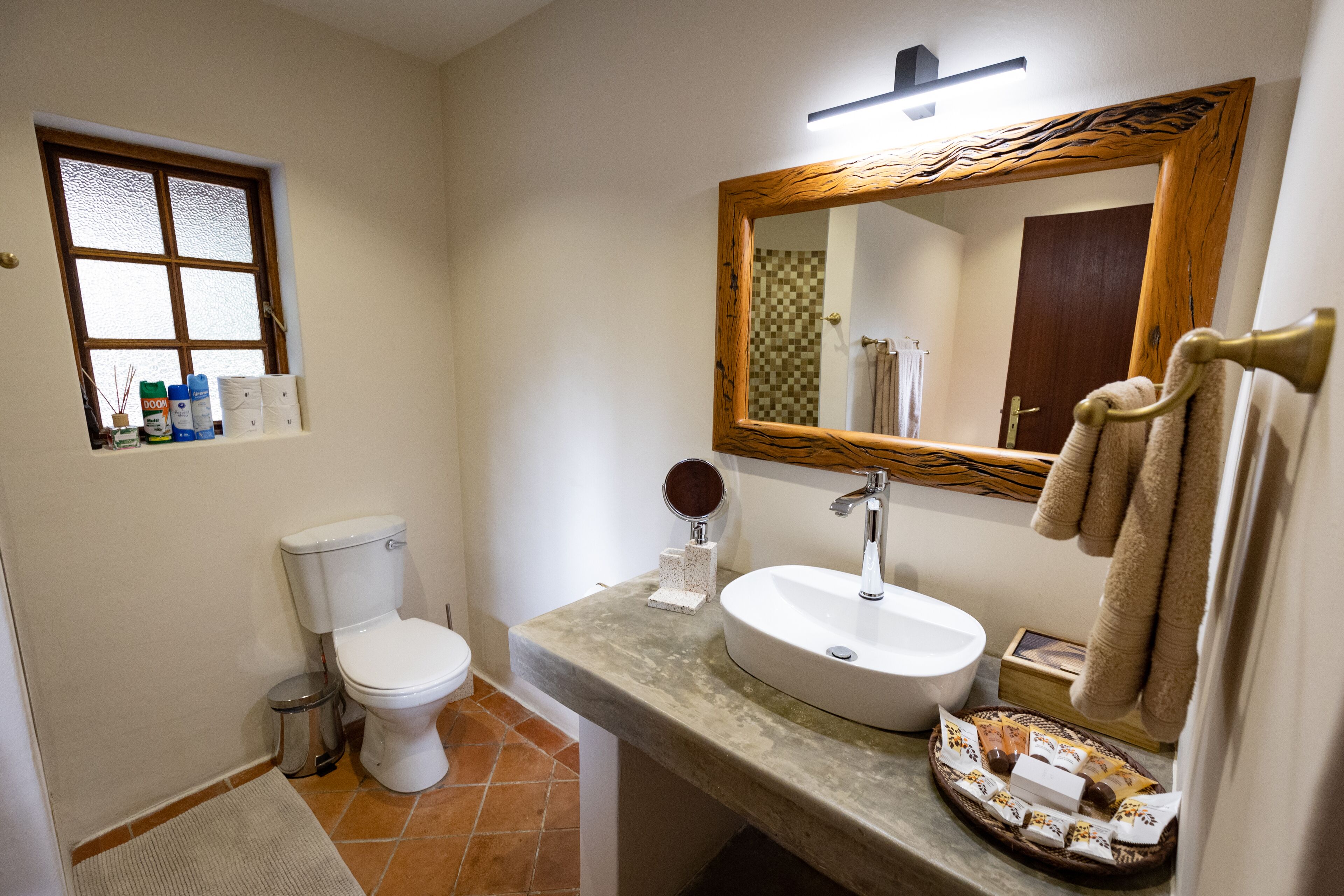 Une salle de bain avec des toilettes, un lavabo et un miroir.