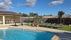 A swimming pool with lounge chairs and a covered patio area. - VILLA L'ESTEL in the countryside with private pool 10 minutes from Arles (Tarascon)