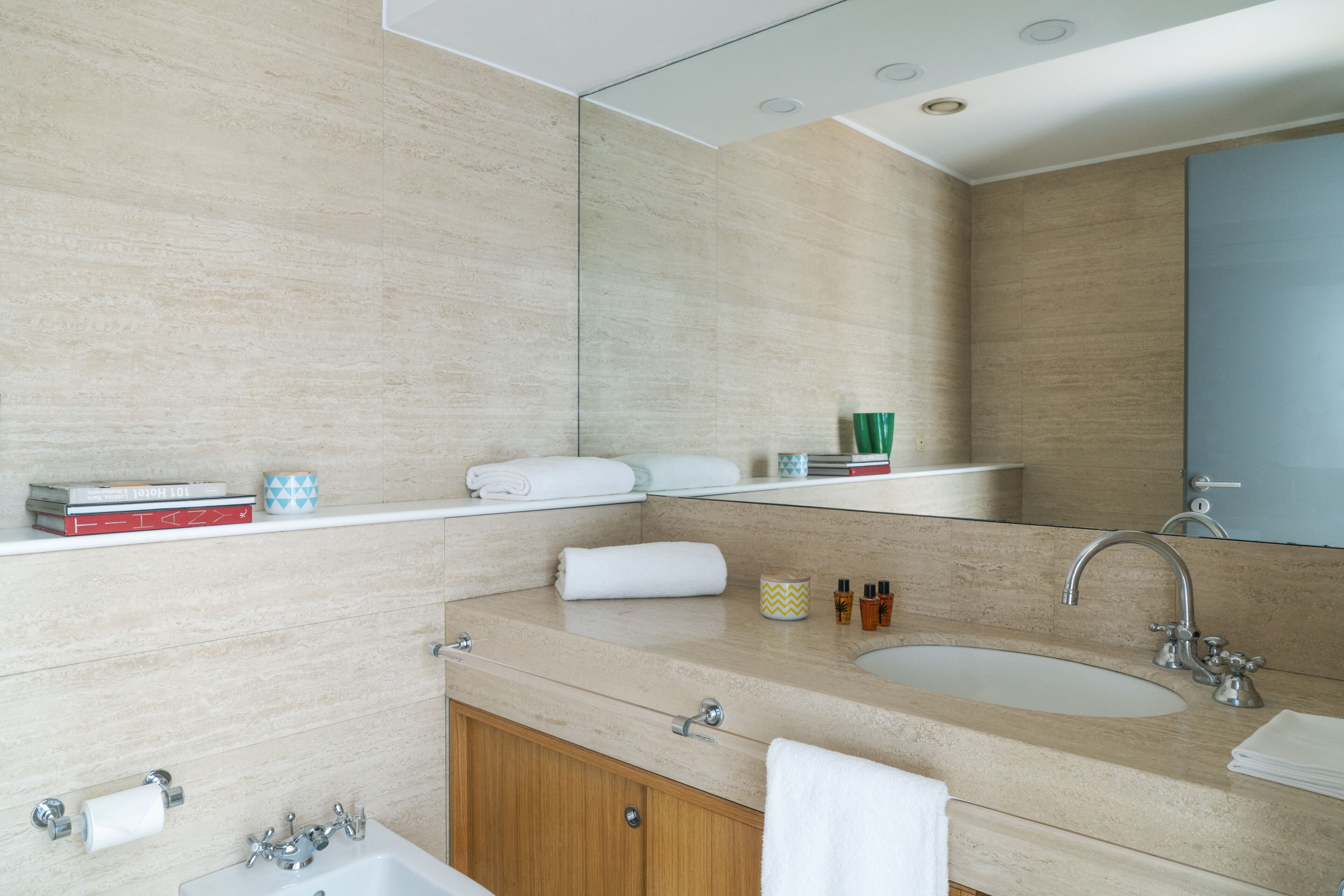 A modern bathroom with a double sink, a large mirror, and a towel rack.
