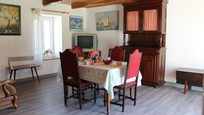 Un comedor con una mesa de madera, sillas y un armario.