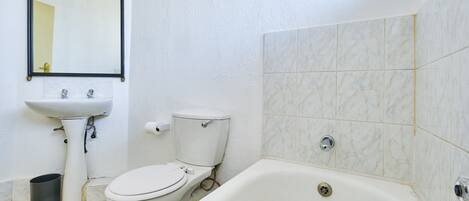 Un baño con inodoro, lavabo y bañera.