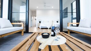 Ein modernes Wohnzimmer mit einem Holztisch, zwei weißen Sofas und einem Esstisch.
