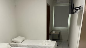 A small, clean room with two single beds, a wooden table, and a small table with a chair. - Bravo City Hotel Sao Carlos (São Carlos)