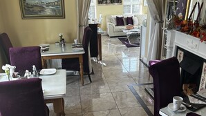 A dining area with a chandelier, dining table, chairs, and a sofa. - Parkhouse Bed and Breakfast (Bunratty)