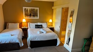 A hotel room with two beds, a painting on the wall, and a mirror reflecting the room. - Parkhouse Bed and Breakfast (Bunratty)