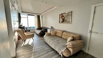 A modern living room with a sofa, armchair, and a coffee table.