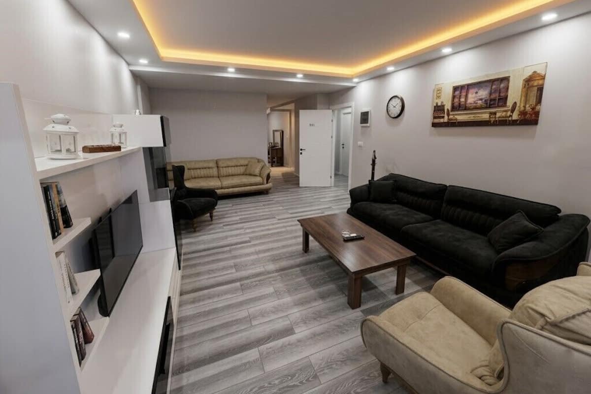 Una sala de estar moderna con un sofá, una mesa de centro y un televisor.