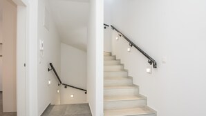 A staircase with a handrail, light switches, and a phone on the wall. - Apartment Spanic 2 (Vir)
