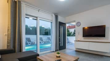 Deluxe Apartment A1 | Oppholdsområde | En 100-centimeters Flatskjerm-TV med Parabol-TV samt TV