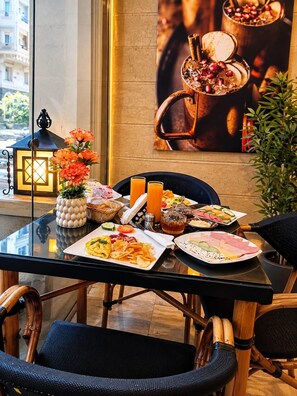A dining table with breakfast items, a vase with flowers, and a lantern. - Jasmine Pyramids Hotel (Giza)