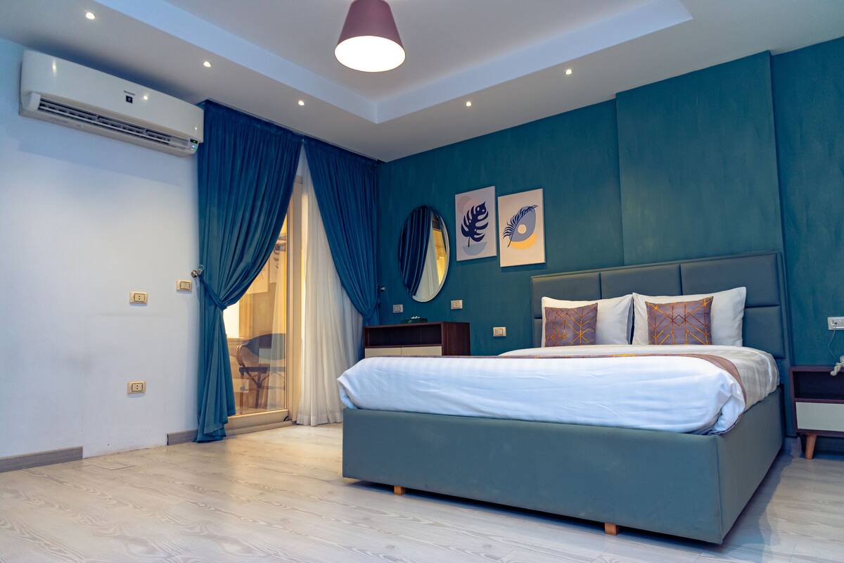 Un dormitorio moderno con una cama grande, un armario empotrado y un ventilador de techo.