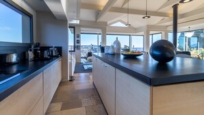 Una cocina moderna con una isla grande, vistas de la ciudad y un comedor.