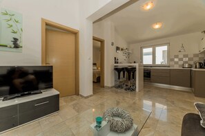 Apartamento conforto (A2) | Área de estar | TV de tela plana 100 cm com canais via satélite, TV