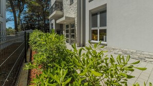 A modern building with a stone facade, large windows, and a balcony. - Apartment Stichling (Vir)