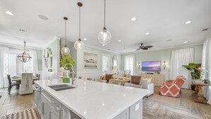 A spacious kitchen with a large island, modern pendant lighting, and a dining area with a view of the living room. - Renovated Seagrove Home with LSV & Pool Access (Santa Rosa Beach)