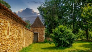 Un bâtiment en pierre avec une porte en bois et une petite tour.
