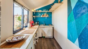 Eine kleine Küche mit Fenster, Spüle und Arbeitsplatte.