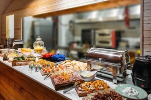 Un bufé con diferentes opciones de comida y una máquina de café.