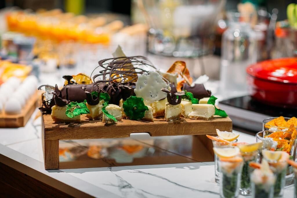 A buffet with various dishes, including a chocolate dessert and cheese.