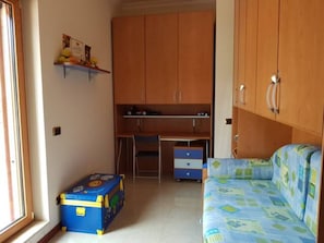 Una stanza con un letto, una scrivania e un armadio.