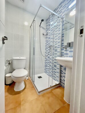 Een douche, handdoeken, zeep, shampoo