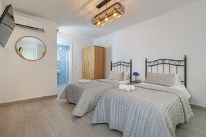 Una camera da letto con due letti, un armadio, uno specchio e un lampadario.