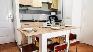 Una cocina moderna con una mesa de comedor, sillas y una cafetera.
