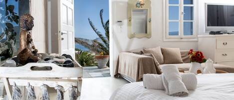 A bedroom with a bed, a bedside table, a mirror, and a television.