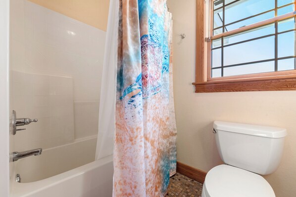 A bathroom with a bathtub, toilet, and a window. - The Edge Of Reality: Private Pool, Spa, Rec Room (Corolla)