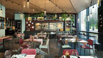 A restaurant interior with multiple dining tables, chairs, and hanging plants.