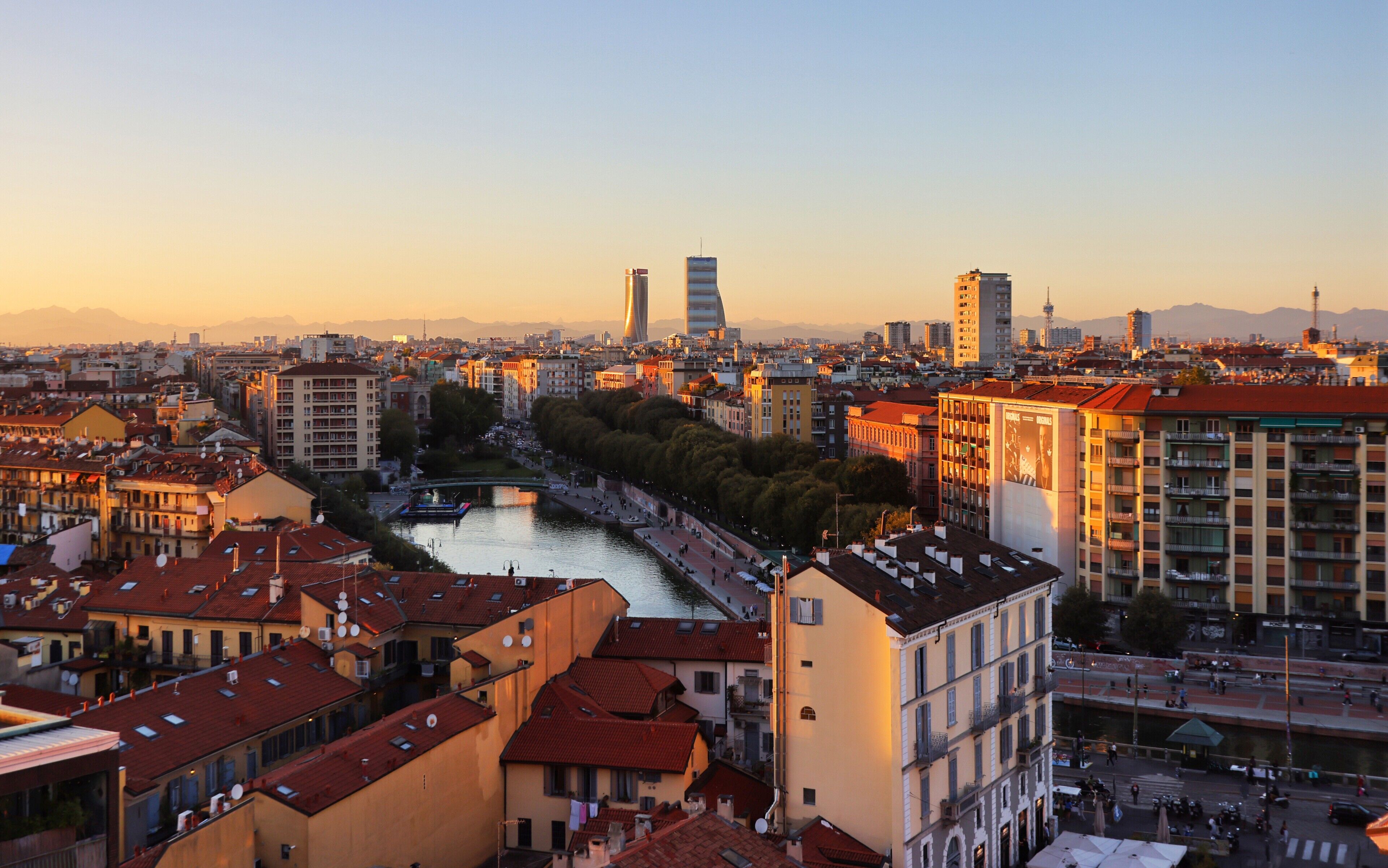 Un paisaje urbano con un río, edificios y un puente.