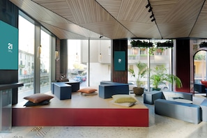 A modern lobby with seating areas, large windows, and a number display. - 21 House of Stories Navigli (Milan)