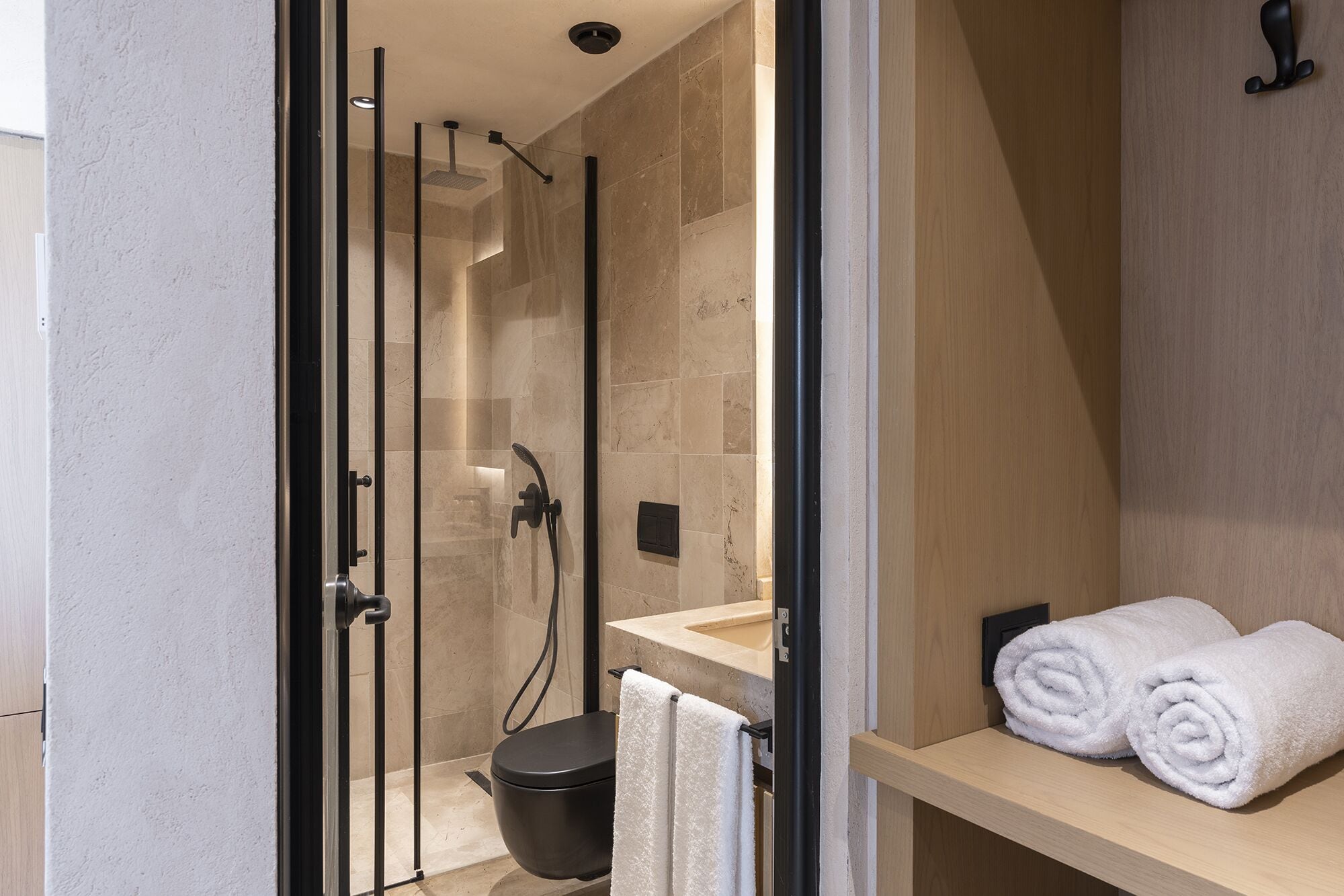 Une salle de bain moderne dotée d’une douche à parois de verre, de toilettes et d’un lavabo avec un porte-serviettes.