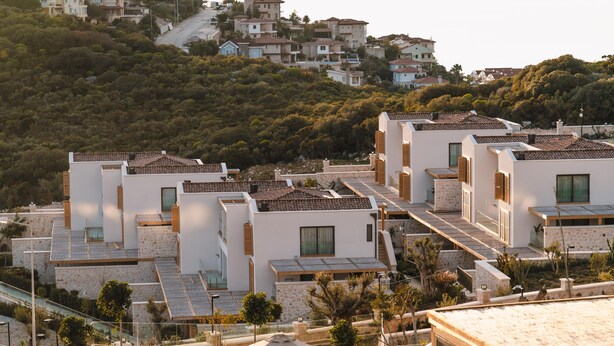 Zona residencial con casas modernas de techos planos y un paisaje montañoso de fondo.