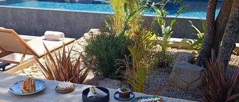 Una piscina al aire libre de temporada, sombrillas