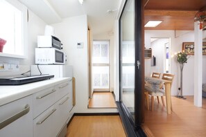 A compact kitchen with white cabinets, a microwave, and a small countertop.