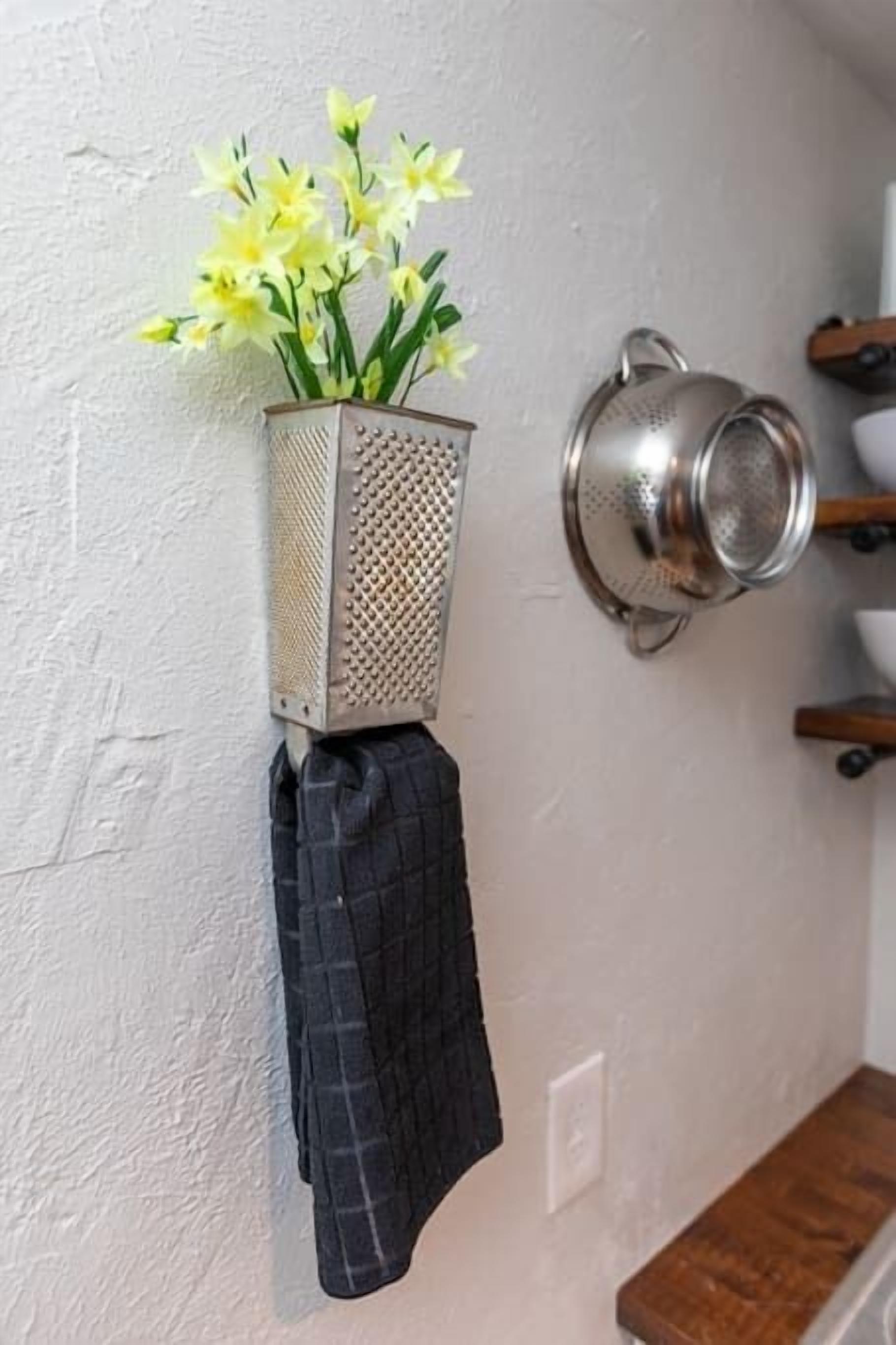A kitchen with a hanging pot rack, a colander, and a cloth hanging from the rack.