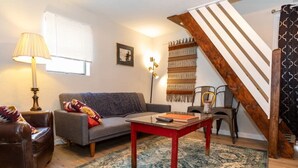 A cozy living room with a sofa, armchair, and a coffee table. - Cozy & Comfy Cottage in the City - w/ parking! (Pittsburgh)