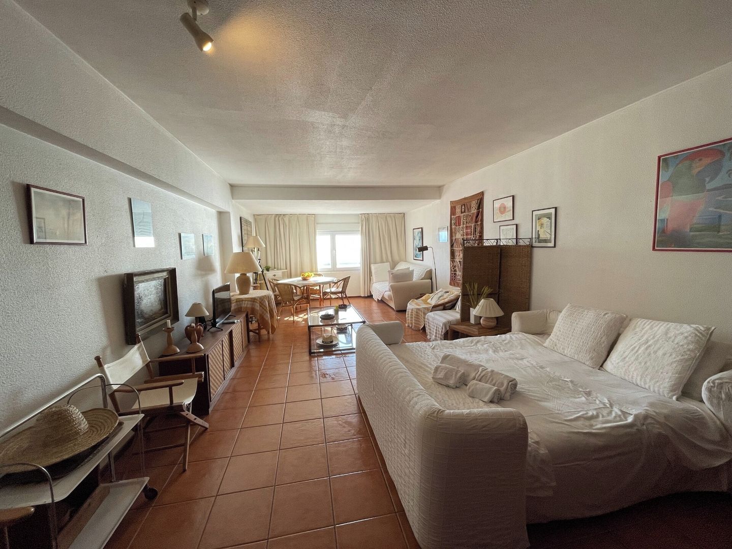 Une chambre d’hôtel avec un lit, un canapé, une table à manger et un téléviseur.