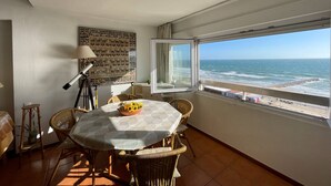 Una habitación con una mesa lista para comer, vista al océano y pared con diseño.