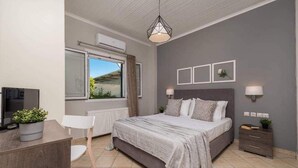 Un dormitorio con cama, mesitas de noche, escritorio y silla.