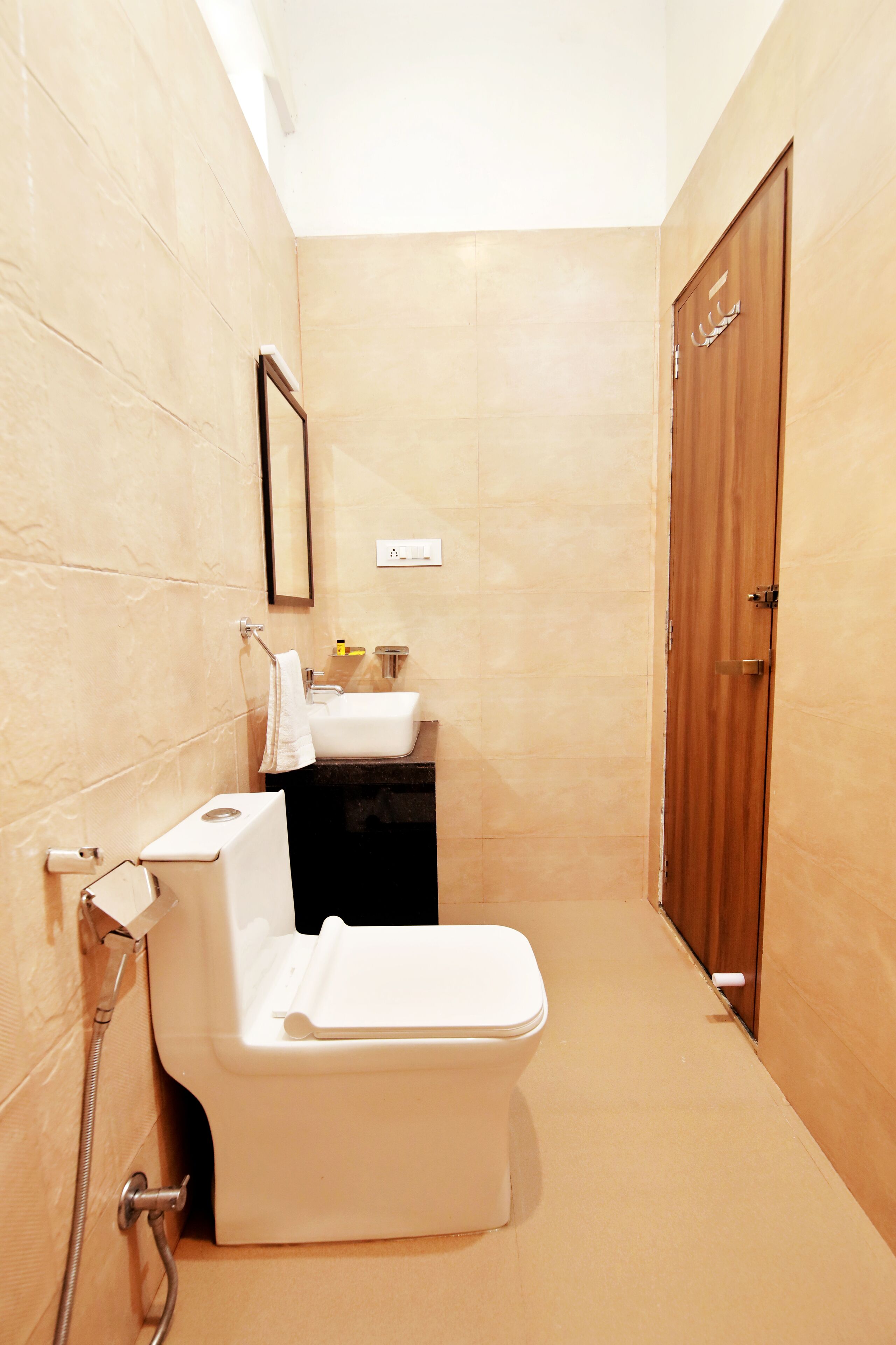 A small bathroom with a toilet, sink, and wooden door.