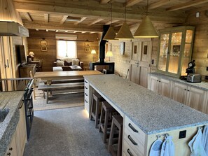 Interior de una cabaña de madera con cocina, comedor y sala de estar.