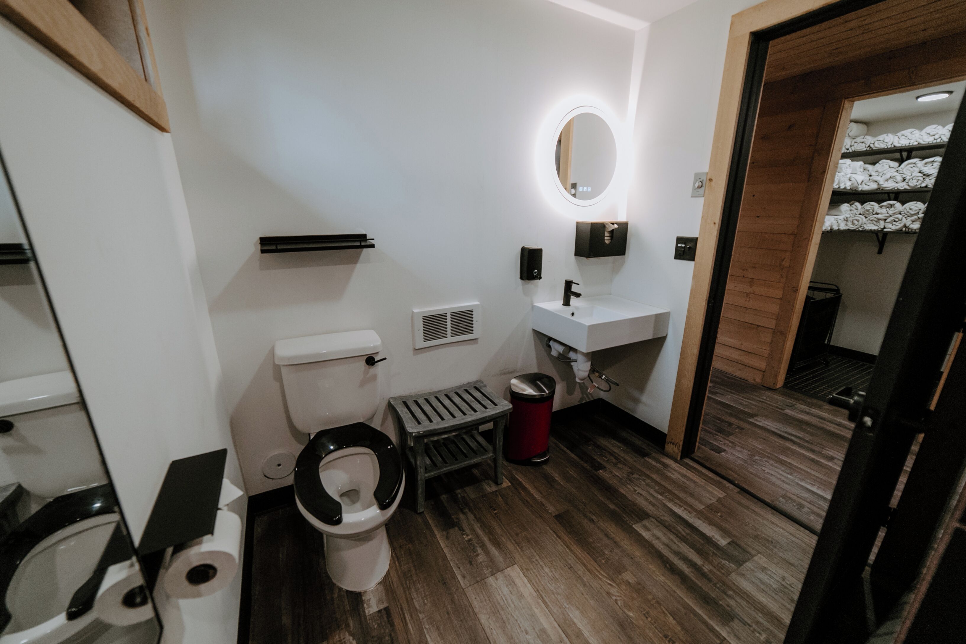 A modern bathroom with a toilet, sink, and mirror.