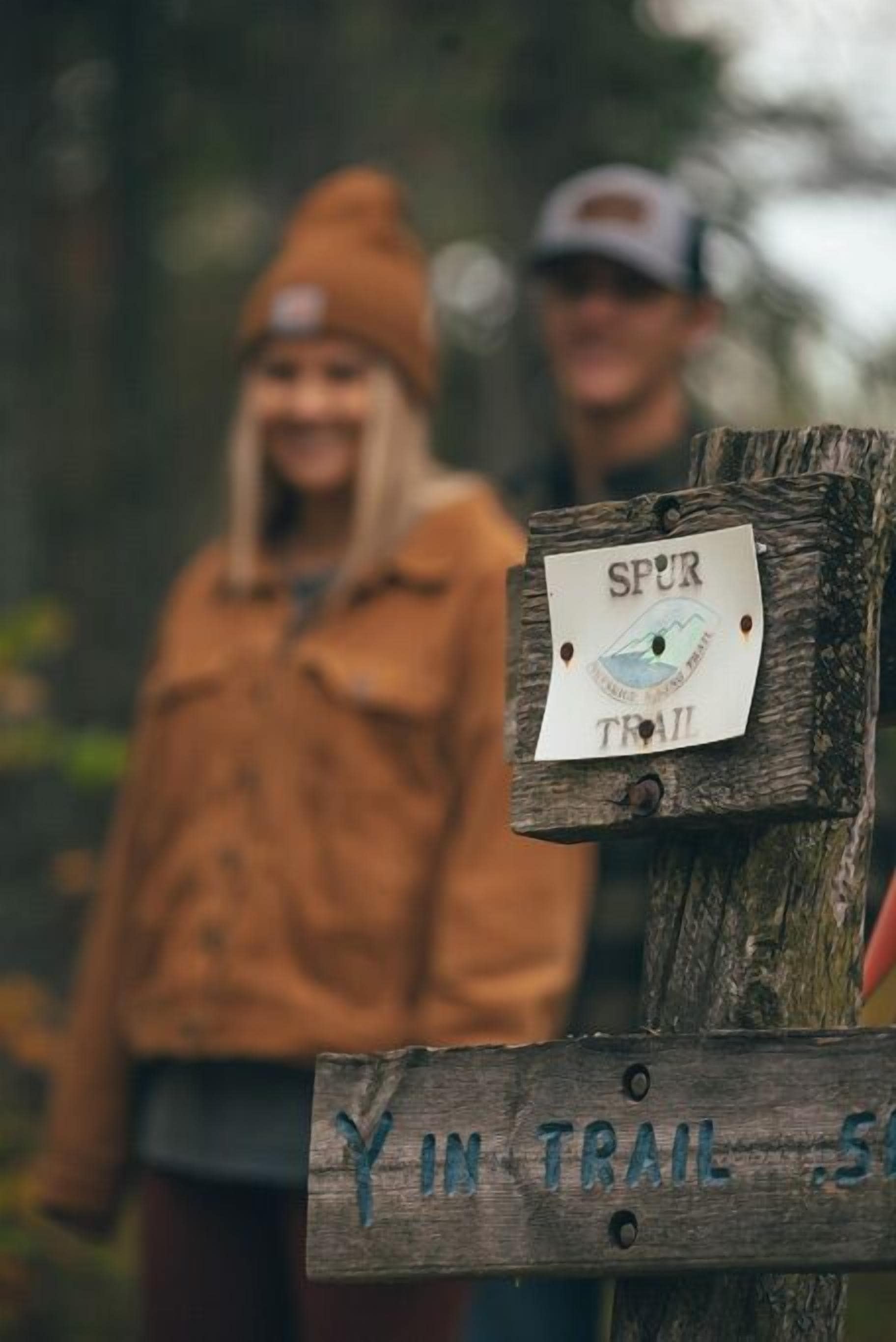 A wooden signpost with 'SPUR TRAIL' and 'YIN TRAIL' written on it.
