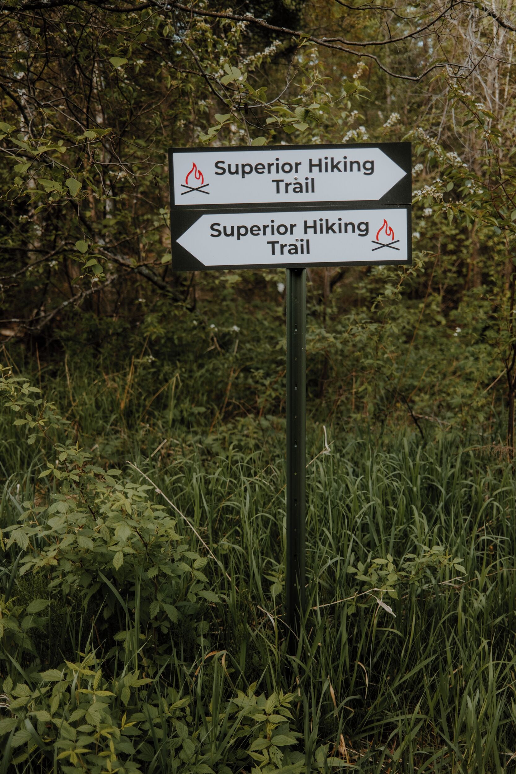 A directional sign for the Superior Hiking Trail with a fire symbol.